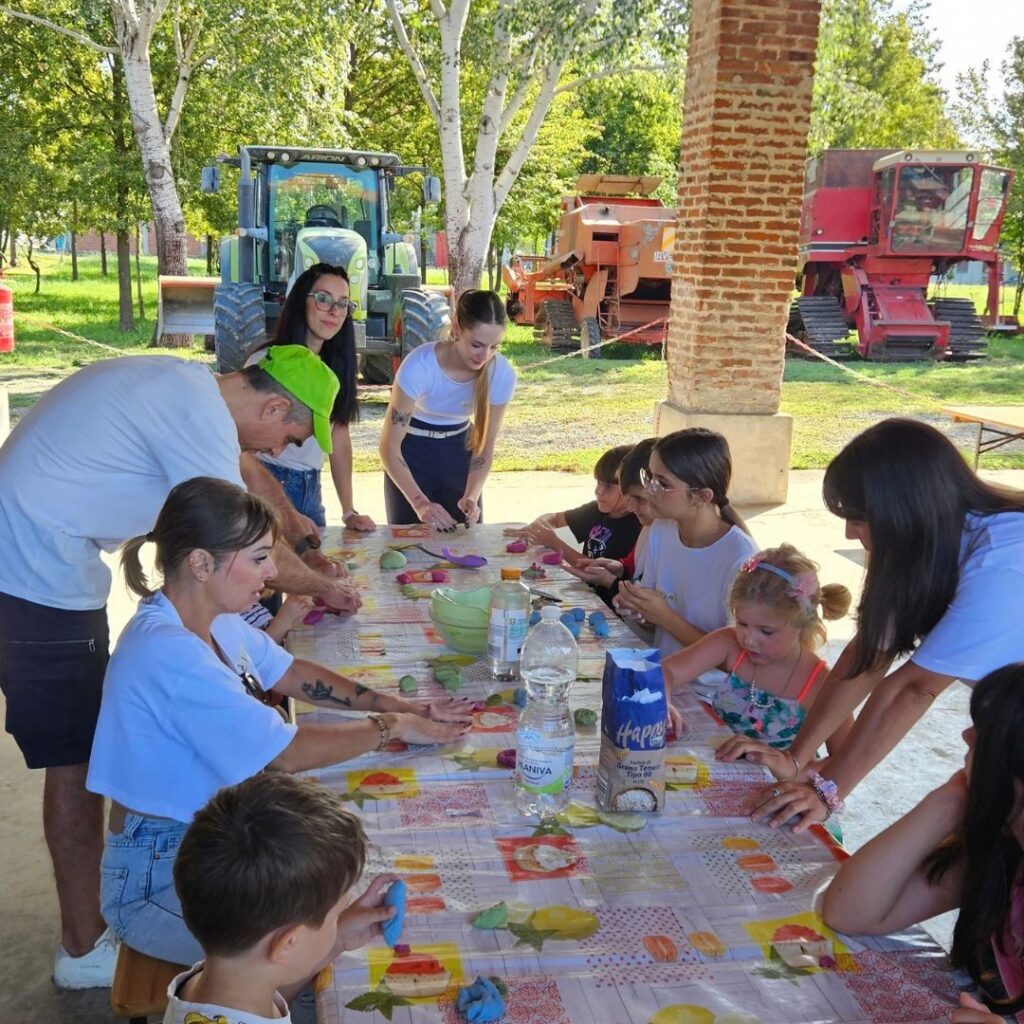Attività in fattoria per bambini: com'è andata la giornata di Nutriziopoli alla Cascina Teglio? Tavoli del laboratorio all'aperto con le famiglie, attività in fattoria per bambini di Nutriziopoli